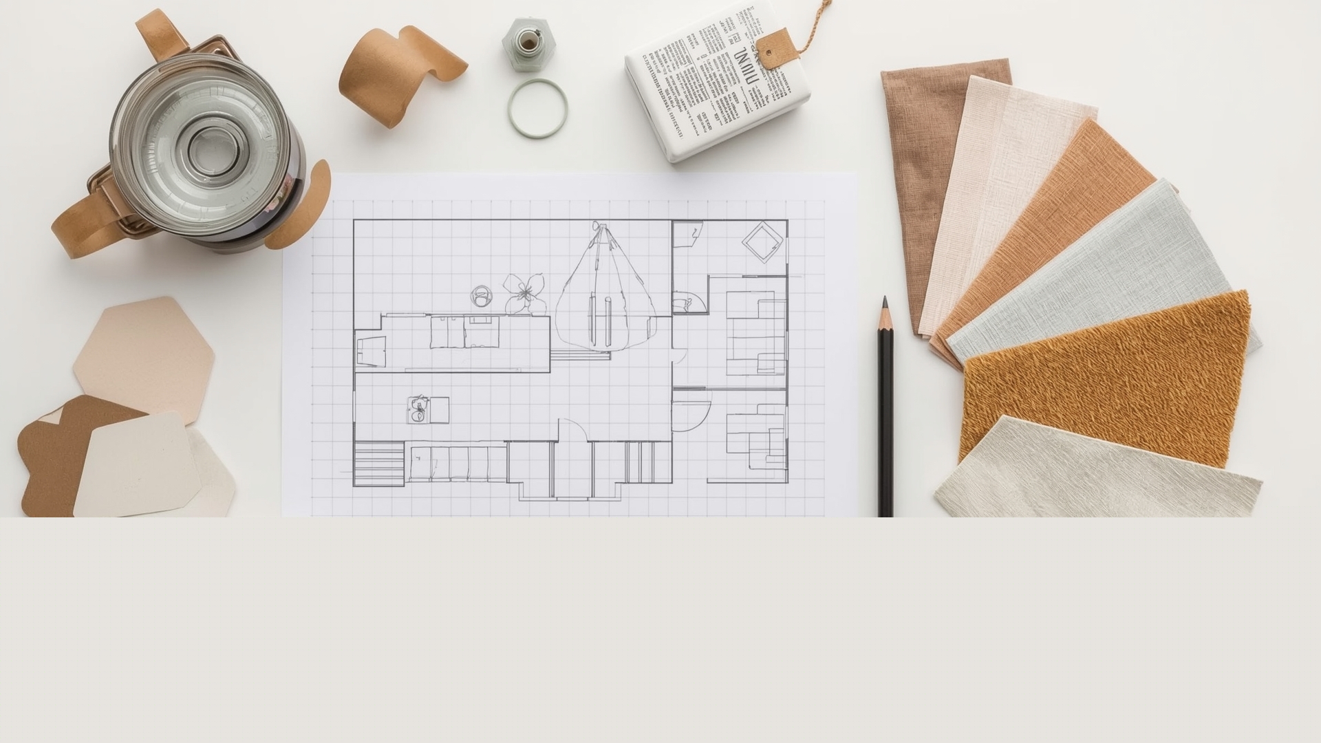 Overhead flat lay of interior design planning tools including floor plans and color swatches on white table